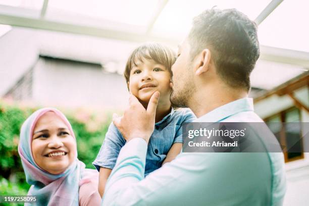 doting father kissing his little son - indonesischer archipel stock-fotos und bilder