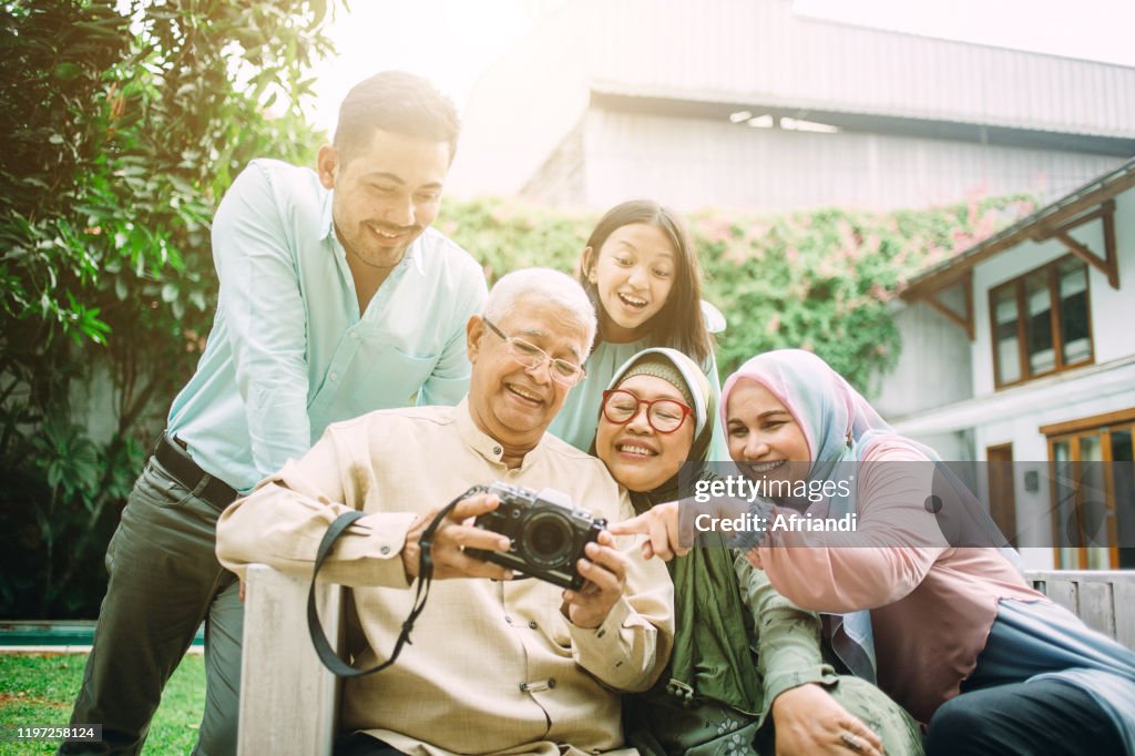 Family watching together pictures from birthday party