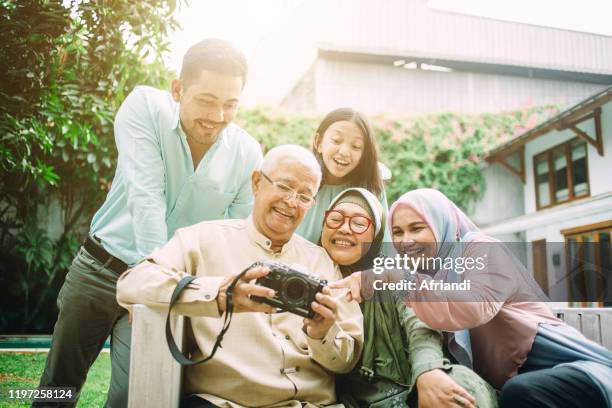 family watching together pictures from birthday party - malay archipelago stock pictures, royalty-free photos & images