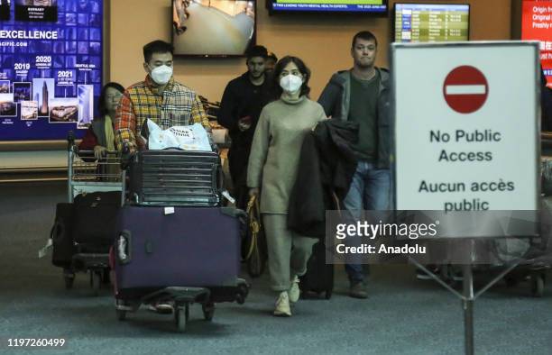 People wearing face masks are seen at Vancouver International Airport in Vancouver, British Columbia, Canada on January 28, 2020. Vancouver health...