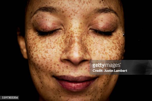 close up of freckles on mixed race woman with her eyes closed - woman portrait eyes closed stock pictures, royalty-free photos & images