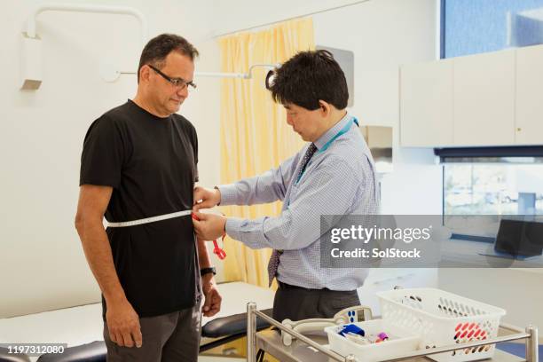 doctor measuring patient's stomach - measure waist stock pictures, royalty-free photos & images