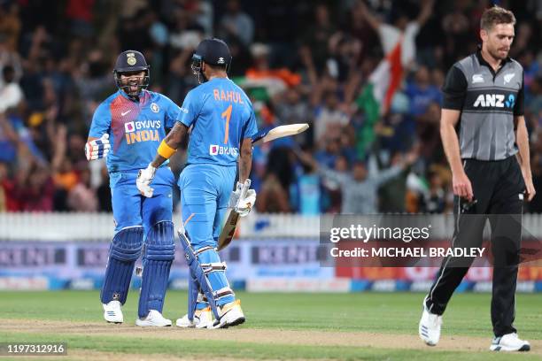 Indias Rohit Sharma celebrates with KL Rahul after hitting the winning runs as New Zealands Tim Southee looks on during the third Twenty20 cricket...