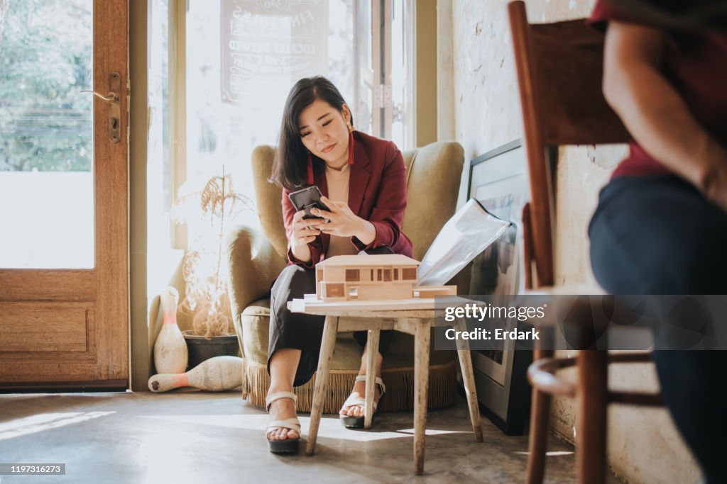 Femmes thaïlandaises d'architecte bavardant à son mari après avoir travaillé tout en s'asseyant au café