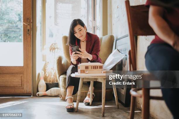 thai architect women chatting to her husband after working while sitting at the cafe - social engagement stock pictures, royalty-free photos & images