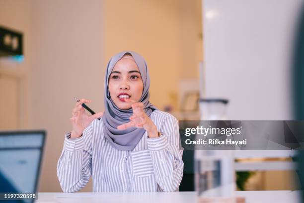 porträt muslimischer frauen, die im besprechungsraum diskutieren - woman hijab stock-fotos und bilder