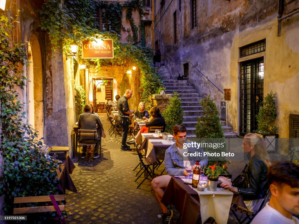 Some Tourists Enjoy Life In A Typical Italian Restaurant In The