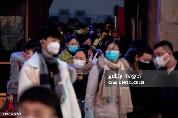 Passengers, wearing protective facemasks, are seen at the arrival area of the Beijing Railway station on January 29, 2020. - The number of confirmed...