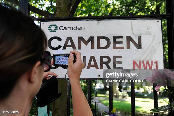 Woman takes a picture of the road sign "Camden Square" in north London on July 24 near the house where the body of pop star Amy Winehouse was found...