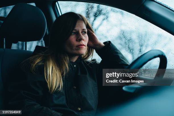 a woman sits in a car. - winter car window foto e immagini stock