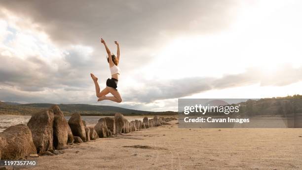 girl jumping happy at the sea - girl shaving legs stock pictures, royalty-free photos & images