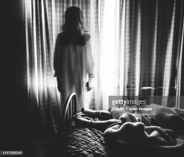spooky image of ghost girl staring at someone sleeping in bed - demon stock pictures, royalty-free photos & images