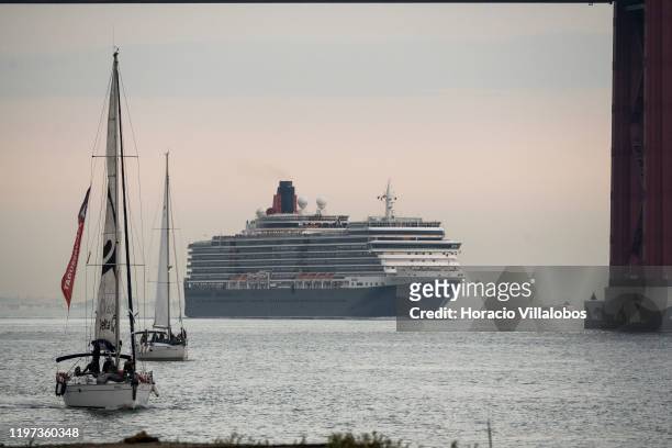 Sailboats with tourists on sunset tours navigate near MS Queen Victoria, a cruise ship currently owned and operated by Cunard Line, sailing the Tagus...