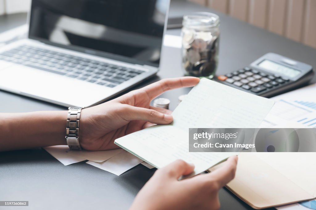 Accountant hands holding saving account passbook, book bank.