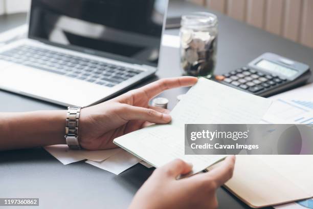 accountant hands holding saving account passbook, book bank. - electronic document stock pictures, royalty-free photos & images