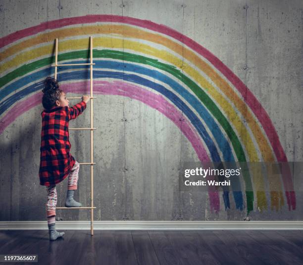 girl climbing to reach the rainbow - girl rising stock pictures, royalty-free photos & images