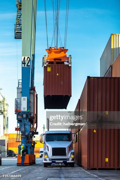 straddle carrier lifting cargo container from truck - port of los angeles stock pictures, royalty-free photos & images