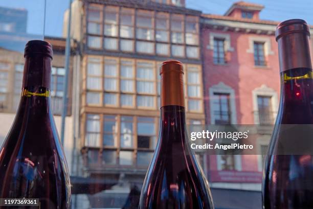 three bottles of wine on display in the square of a village with a wine tradition - three storey stock pictures, royalty-free photos & images