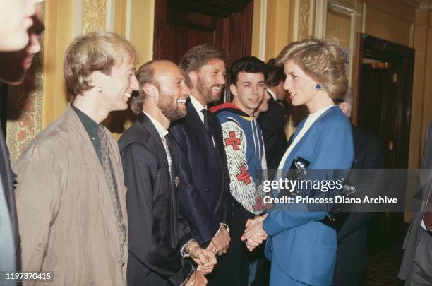 Diana, Princess of Wales meets pop group the Bee Gees at the Cafe Royal in London, during a luncheon to launch Capital Radio's Help A London Child...