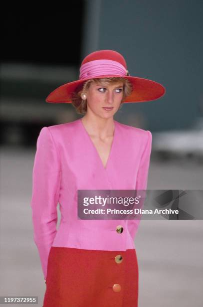 Diana, Princess of Wales arrives at the airport in Abu Dhabi in the United Arab Emirates, March 1989. She is wearing a pink and red dress by...