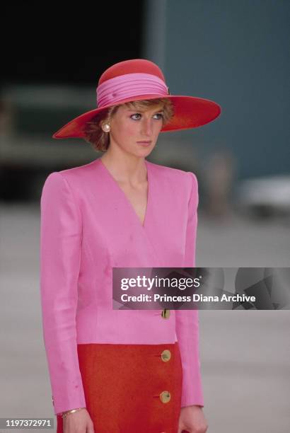 Diana, Princess of Wales arrives at the airport in Abu Dhabi in the United Arab Emirates, March 1989. She is wearing a pink and red dress by...