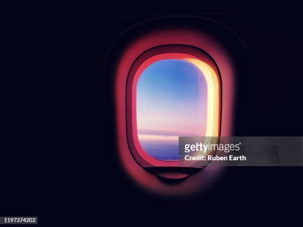 commercial airplane passenger window during sunset with wright warm colors while flying and copy space - airplane window stockfoto's en -beelden