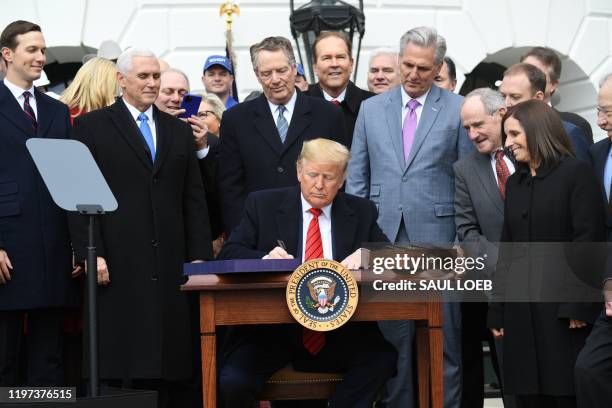 President Donald Trump signs the United States - Mexico -Canada Trade Agreement, known as USMCA, during a ceremony on the South Lawn of the White...