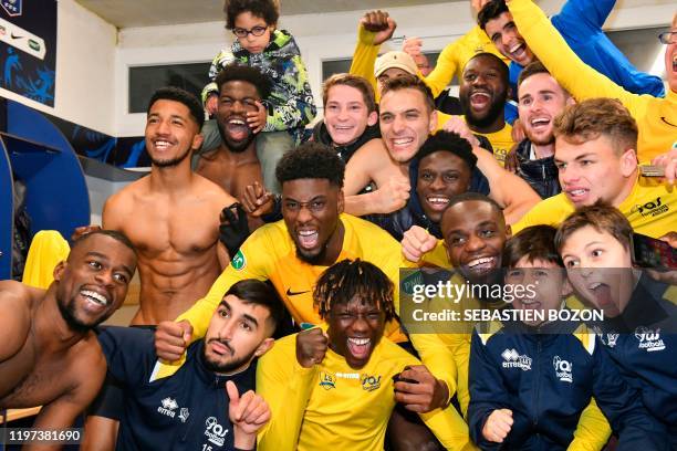 Epinal's players celebrate their team's win at the end of the French Cup round-of-16 football match between Epinal and Lille at the stade de la...