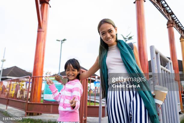 mother and daughter at amusement park. - theme park singapore stock pictures, royalty-free photos & images
