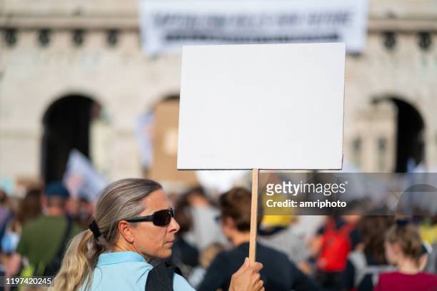 climate activist with white sign at fridays for future demonstration - placard stock pictures, royalty-free photos & images