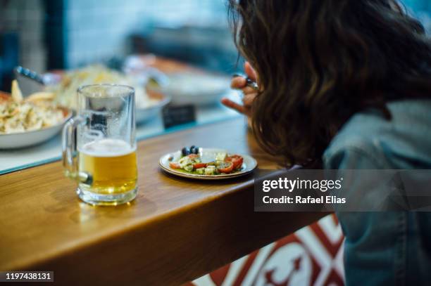 woman eating tapas at the bar counter - tapas spain stock pictures, royalty-free photos & images