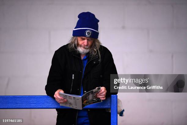 Rochdale AFC fan reads the matchday programme prior to the FA Cup Third Round match between Rochdale AFC and Newcastle United at Spotland Stadium on...