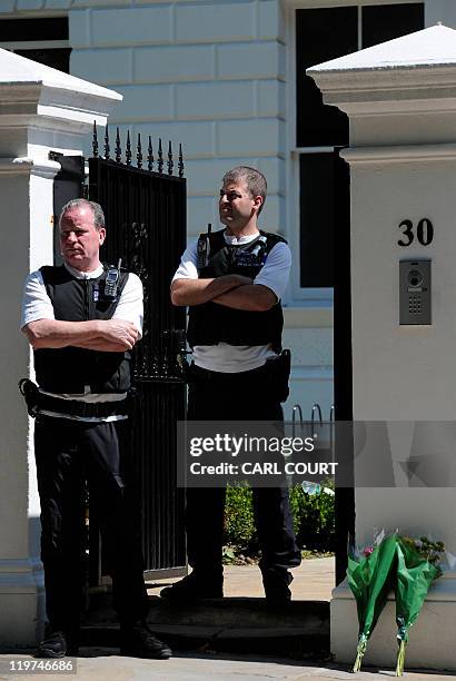 Police officers stand guard outside a house in north London on July 24 where the body of pop star Amy Winehouse was found the previous day. The Fans...