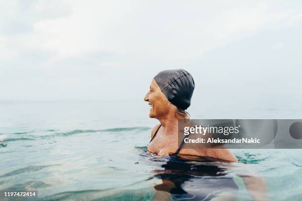 senior female swimmer in the sea - swimming stock pictures, royalty-free photos & images