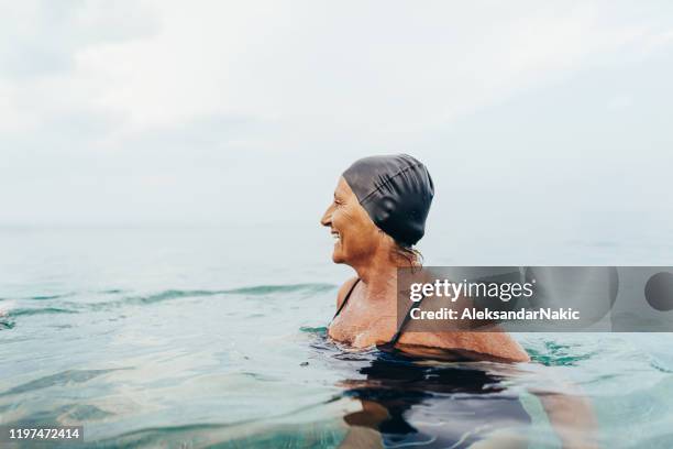 senior female swimmer in the sea - competitive swimming stock pictures, royalty-free photos & images