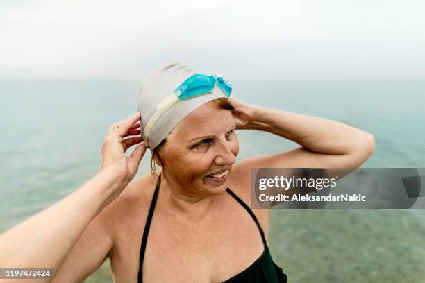 nadadora mayor en el mar - gorro-de-baño fotografías e imágenes de stock