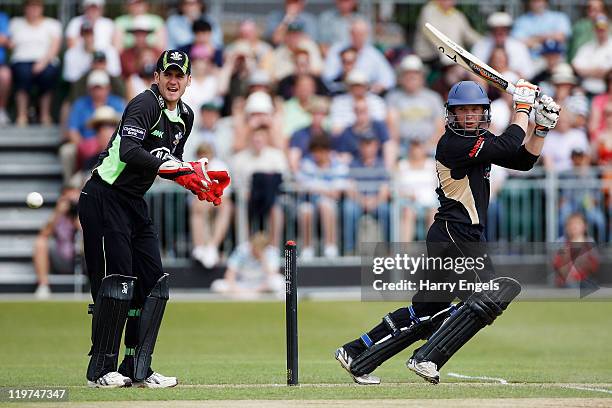 Tim Ambrose of Warwickshire hits out watched by Steven Davies of Surrey during the Clydesdale Bank 40 match between Surrey and Warwickshire at...