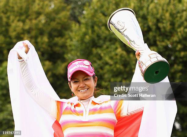 Ai Miyazato of Japan celebrates with the trophy after her victory at the Evian Masters at the Evian Masters Golf Club on July 24, 2011 in...