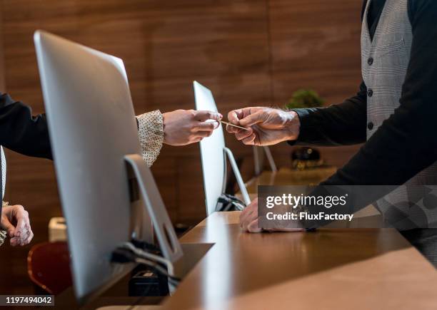 businessman checking out at reception - luxury hotel service stock pictures, royalty-free photos & images