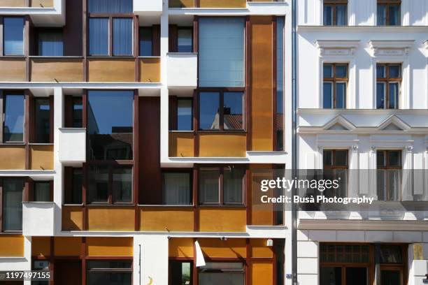 contrast between old pre-war residential building and modern condominium housing building in the district of mitte, in berlin, germany - modern apartment balcony stockfoto's en -beelden