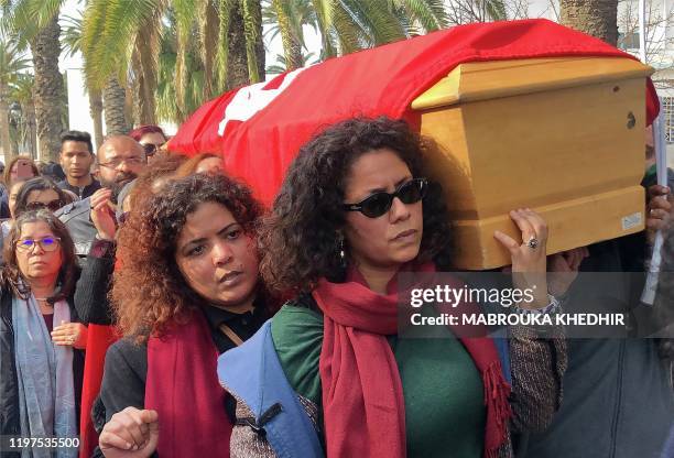 Tunisian women carry the coffin of human rights defender, internet-activist and blogger Lina Ben Mhenni during her funeral procession on January 28,...