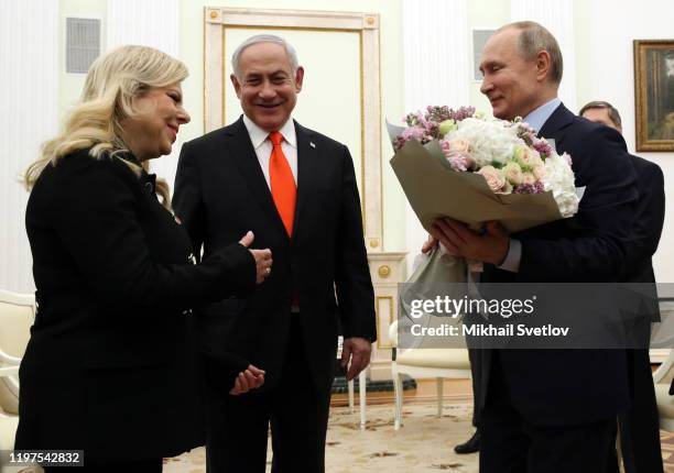 Russian President Vladimir Putin greets Israeli Prime Minister Benjamin Netanyahu and his wife Sara Netanyahu dduring their meeting at the Kremlin on...