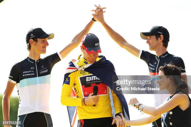 Andy Schleck of team Leopard congratulates his teammate and brother Frank Schleck as Cadel Evans of team BMC celebrates winning the 2011 Tour De...