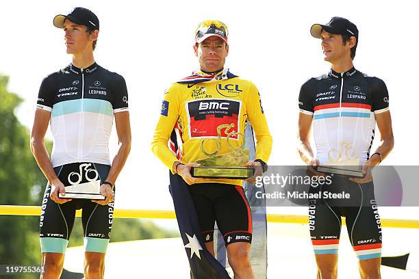 Yellow Jersey winner Cadel Evans of team BMC celebrates with Andy Schleck and Frank Schleck of team Leopard Trek on the podium after the twenty first...