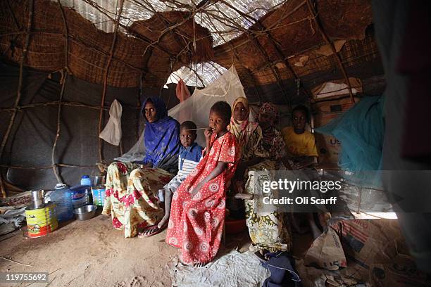 Somali refugee family sit in their makeshift hut on the edge of the Hagadera refugee camp which makes up part of the giant Dadaab refugee settlement...