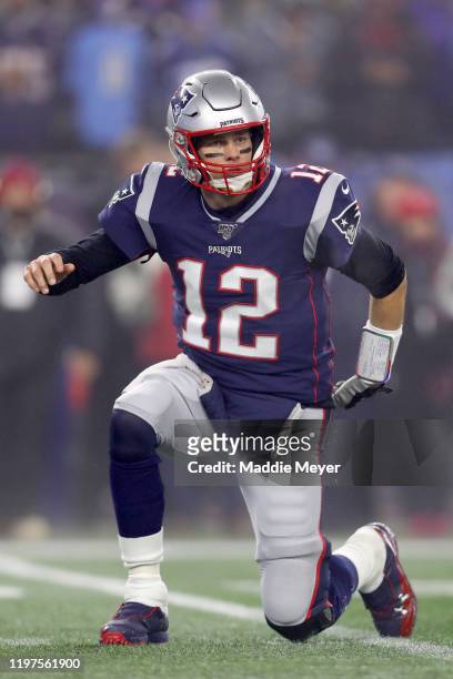 Tom Brady of the New England Patriots stands after getting hit by the Tennessee Titans in the first quarter of the AFC Wild Card Playoff game at...
