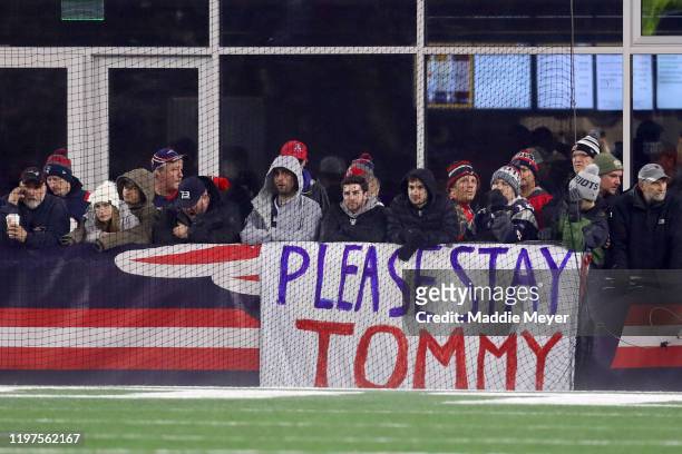 Fans of the New England Patriots hold a sign that reads, "Please Stay Tommy" as they take on the Tennessee Titans in the AFC Wild Card Playoff game...