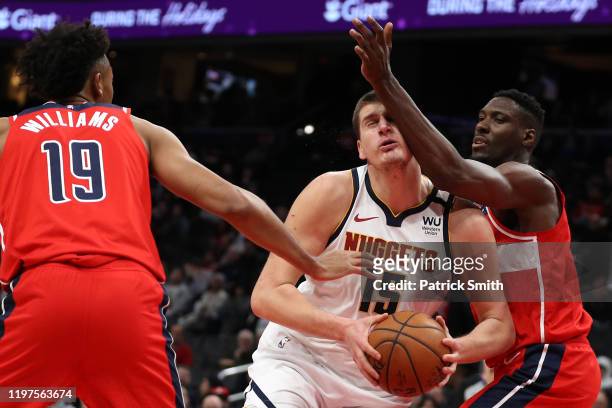 Nikola Jokic of the Denver Nuggets is fouled by Ian Mahinmi of the Washington Wizards during the first half at Capital One Arena on January 04, 2020...