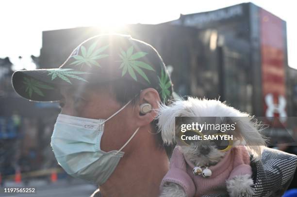 Man wears a protective facemask and carries his dog in Ximen district in Taipei during the Lunar New Year of Rat on January 30, 2020.