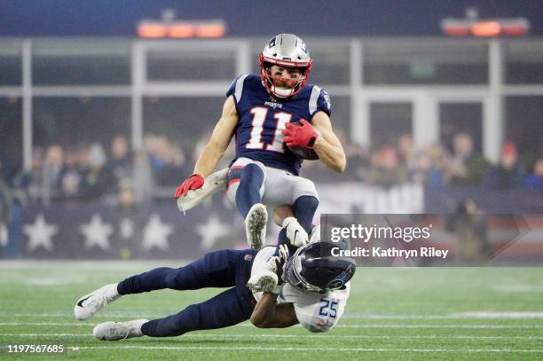 Julian Edelman of the New England Patriots carries the ball against Adoree' Jackson of the Tennessee Titans in the second quarter of the AFC Wild...